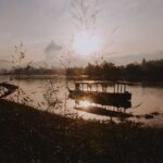 silhouette of boat on water during golden hour